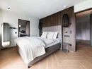 INTERIOS. Dein Interior-Design-Studio. Modernes Schlafzimmer mit Doppelbett, Holzakzenten und minimalistischem Design