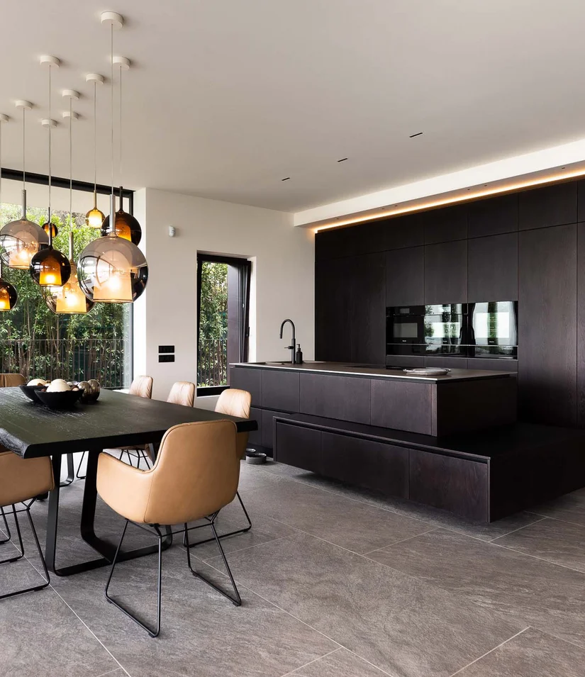 INTERIOS. Dein Interior-Design-Studio. Moderner Essbereich mit braunen Stühlen und dunkler Holzküche