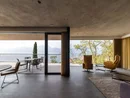 INTERIOS. Dein Interior-Design-Studio. Moderner Wohnraum mit großen Fenstern und Blick auf Terrasse und Berge