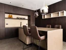 INTERIOS. Dein Interior-Design-Studio. Moderne Küche mit dunklen Holzschränken und zwei braunen Barhockern