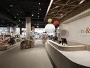 INTERIOS. Dein Interior-Design-Studio. Innenansicht eines modern eingerichteten Babyladen mit Verkaufstheke und Spielsachen
