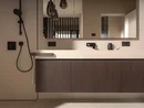 INTERIOS. Dein Interior-Design-Studio. Modernes Badezimmer mit Waschbecken, großem Spiegel und schwarzer Armatur