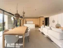 INTERIOS. Dein Interior-Design-Studio. Modernes Wohnzimmer mit Esstisch, weißem Sofa und offener Küche