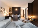 INTERIOS. Dein Interior-Design-Studio. Modern eingerichtetes Wohnzimmer mit hellen Möbeln und dunklen Holzakzenten