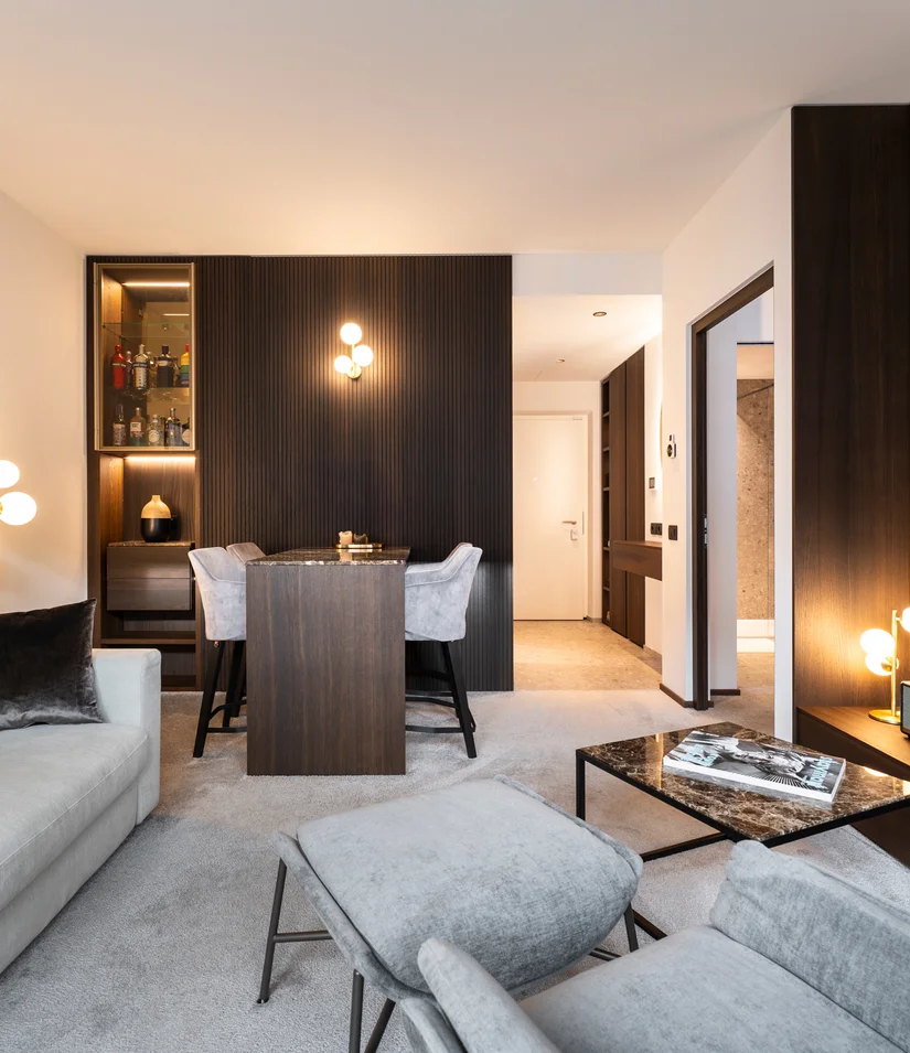 INTERIOS. Dein Interior-Design-Studio. Modern eingerichtetes Wohnzimmer mit hellen Möbeln und dunklen Holzakzenten