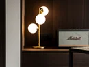 INTERIOS. Dein Interior-Design-Studio. Moderne Tischlampe und Marshall Lautsprecher auf dunklem Holzregal