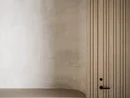 INTERIOS. Dein Interior-Design-Studio. Minimalistische Holzschrankwand mit integriertem rundem Betonregal und schwarzem Türgriff