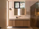 INTERIOS. Dein Interior-Design-Studio. Modernes Badezimmer mit Waschtisch, Spiegel, Pendelleuchten und gläserner Dusche