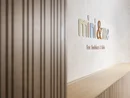 INTERIOS. Dein Interior-Design-Studio. Modernes Kinder- und Babyladen-Schild an einer weißen Wand mit Holzverkleidung