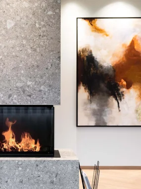 Innenarchitektur und Raumaufteilung Moderner Kamin mit Flammen neben abstraktem Wandbild in elegantem Raum