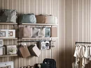 INTERIOS. Dein Interior-Design-Studio. Regale mit Taschen, Kleidung und Babyspielzeug vor Holzvertäfelung