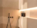 INTERIOS. Dein Interior-Design-Studio. Modernes Badezimmer mit schwarzer Regendusche und zwei Seifenspendern
