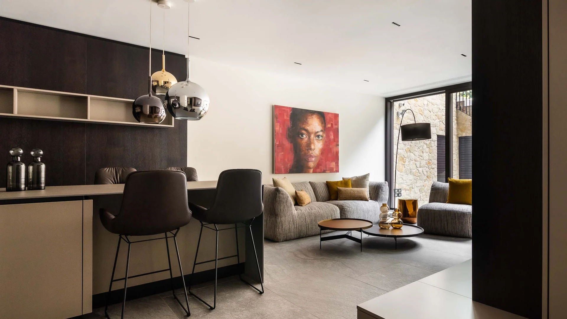 INTERIOS. Dein Interior-Design-Studio. Modernes Wohnzimmer mit Stühlen, Teppich, Kunst an der Wand und großen Fenstern