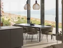 INTERIOS. Dein Interior-Design-Studio. Heller Essbereich mit Pendelleuchten und Blick auf Garten und See
