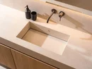 INTERIOS. Dein Interior-Design-Studio. Modernes Waschbecken mit schwarzem Seifenspender und Becher auf hellem Waschtisch
