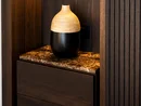 INTERIOS. Dein Interior-Design-Studio. Schwarze und beige Vase auf marmoriertem Holzregal in dunklem Holzschrank